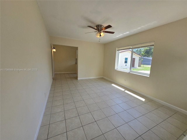 unfurnished room with baseboards, light tile patterned flooring, and ceiling fan