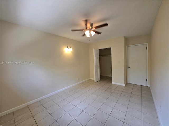 unfurnished bedroom featuring a closet, a ceiling fan, baseboards, and light tile patterned flooring