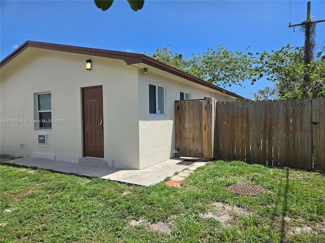 exterior space with a yard, stucco siding, and fence