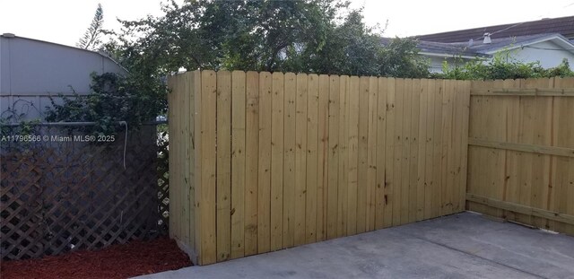 view of gate featuring fence and a patio