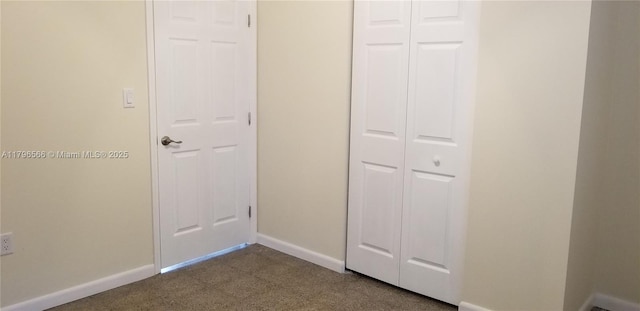interior space with a closet, baseboards, and dark carpet