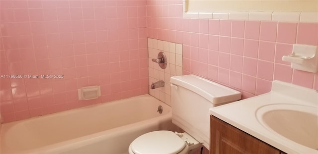 full bath featuring tile walls, toilet, bathing tub / shower combination, and vanity