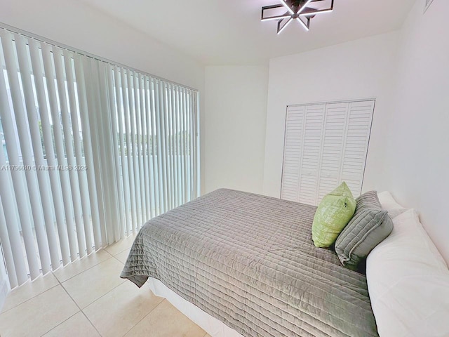 bedroom with tile patterned flooring and a closet