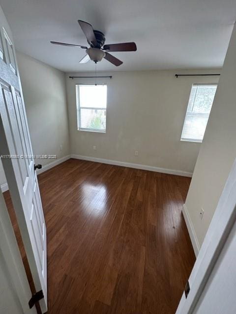 unfurnished room featuring ceiling fan, a wealth of natural light, baseboards, and wood finished floors