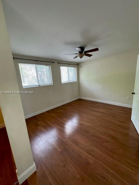 spare room featuring baseboards, a ceiling fan, and wood finished floors