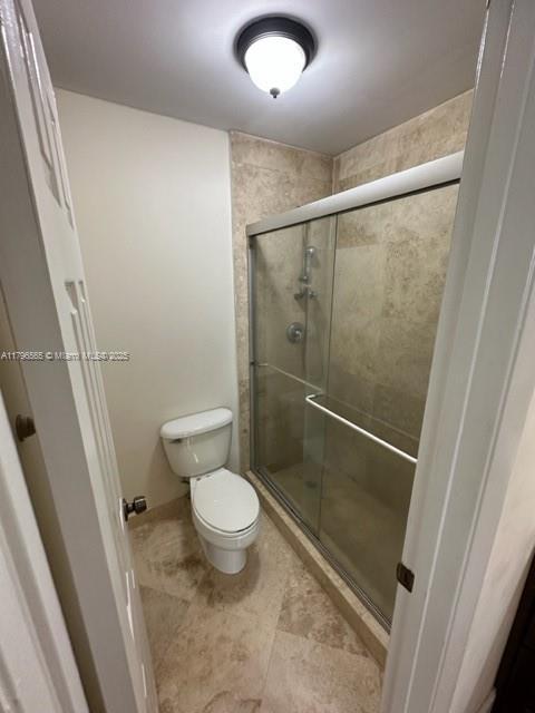 full bath with a stall shower and toilet