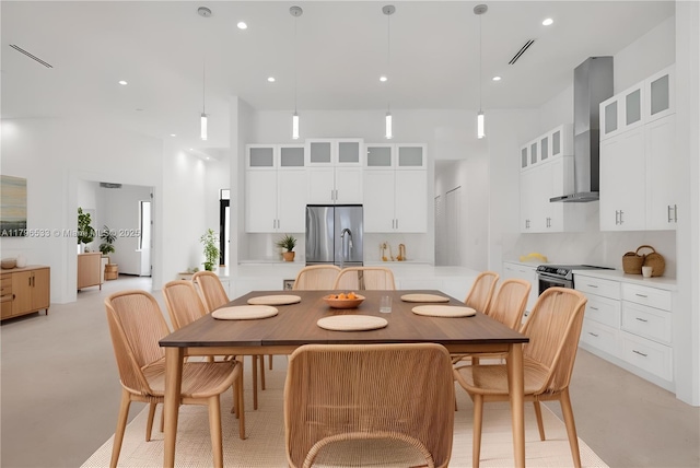 dining area with visible vents, recessed lighting, and a high ceiling