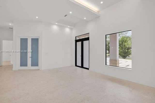 spare room featuring french doors, recessed lighting, and a high ceiling