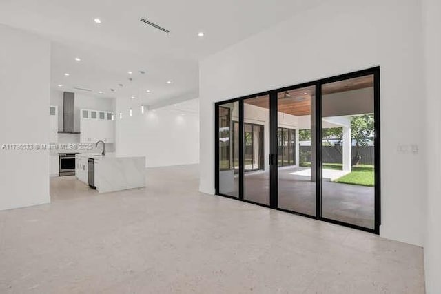 unfurnished living room featuring a sink, visible vents, and recessed lighting