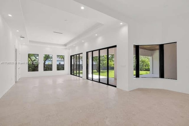 spare room with a wealth of natural light, a tray ceiling, and recessed lighting