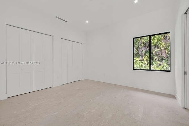 unfurnished bedroom featuring multiple closets and recessed lighting