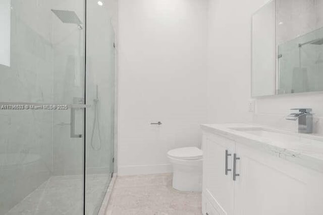 full bath featuring toilet, vanity, tile patterned flooring, a shower stall, and baseboards