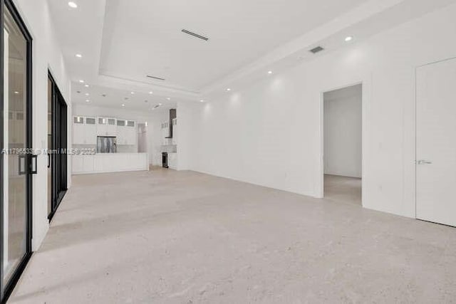 spare room featuring a raised ceiling, visible vents, and recessed lighting