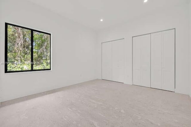 unfurnished bedroom featuring two closets and recessed lighting