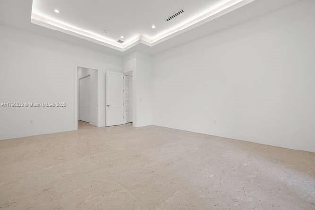 unfurnished room with a tray ceiling and visible vents