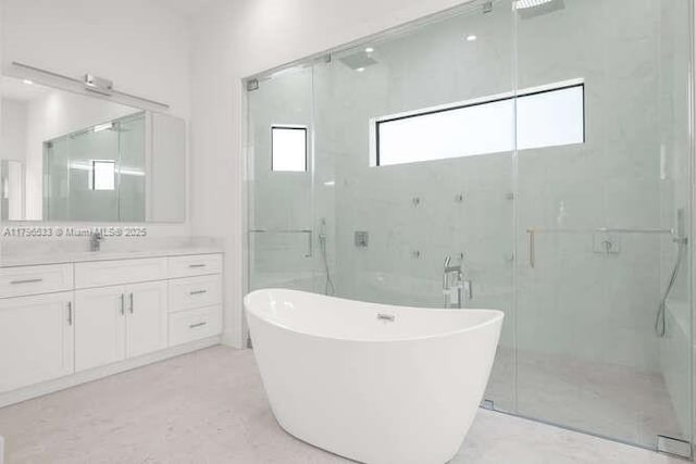 bathroom featuring a freestanding bath, vanity, and a stall shower