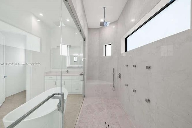 full bathroom with vanity, a bathing tub, and a stall shower