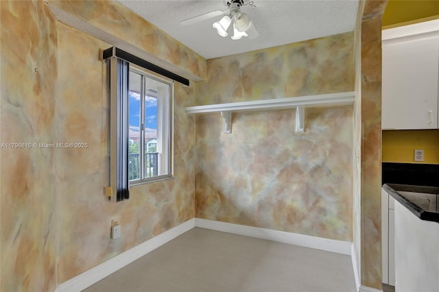 interior space with a textured ceiling, baseboards, and ceiling fan