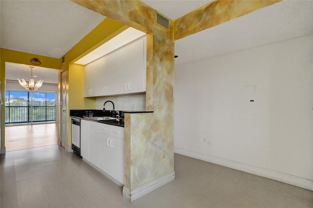 kitchen with a sink, light floors, visible vents, a notable chandelier, and dark countertops