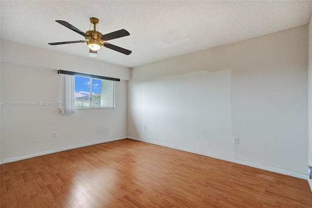 spare room with baseboards, light wood-style flooring, and ceiling fan