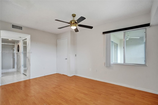 unfurnished bedroom with ceiling fan, baseboards, visible vents, and wood finished floors