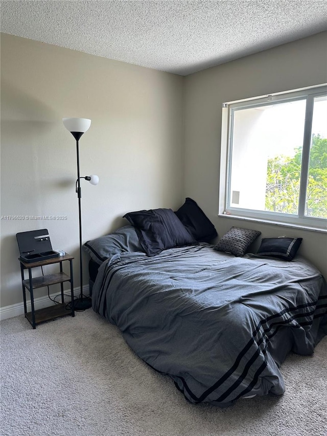 carpeted bedroom with a textured ceiling and baseboards
