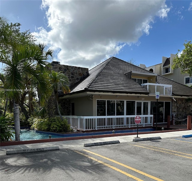 exterior space with a pool and uncovered parking