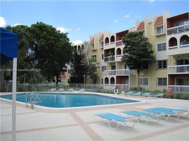 community pool with a patio and fence