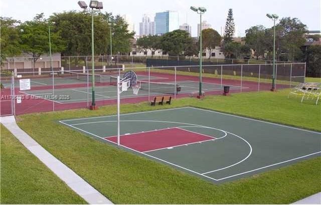 view of sport court with a yard, fence, and a tennis court