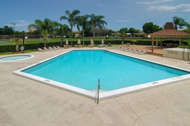 pool with a hot tub, a gazebo, and a patio