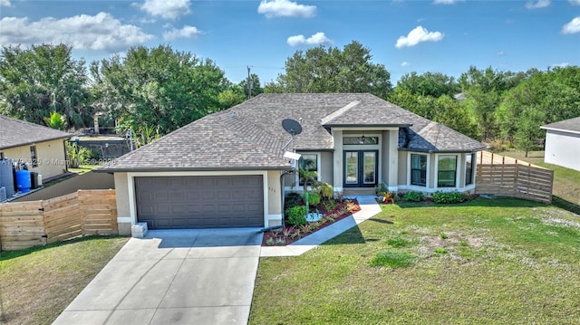 432 Piedmont St, Lehigh Acres, FL 33974 - view of front facade featuring french doors, a garage, concrete driveway, stucco siding, and a shingled roof