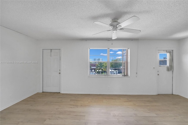 interior space featuring a ceiling fan, a wealth of natural light, light wood-type flooring, and a textured ceiling