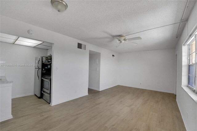 unfurnished living room featuring a textured ceiling, visible vents, light wood-style flooring, and ceiling fan