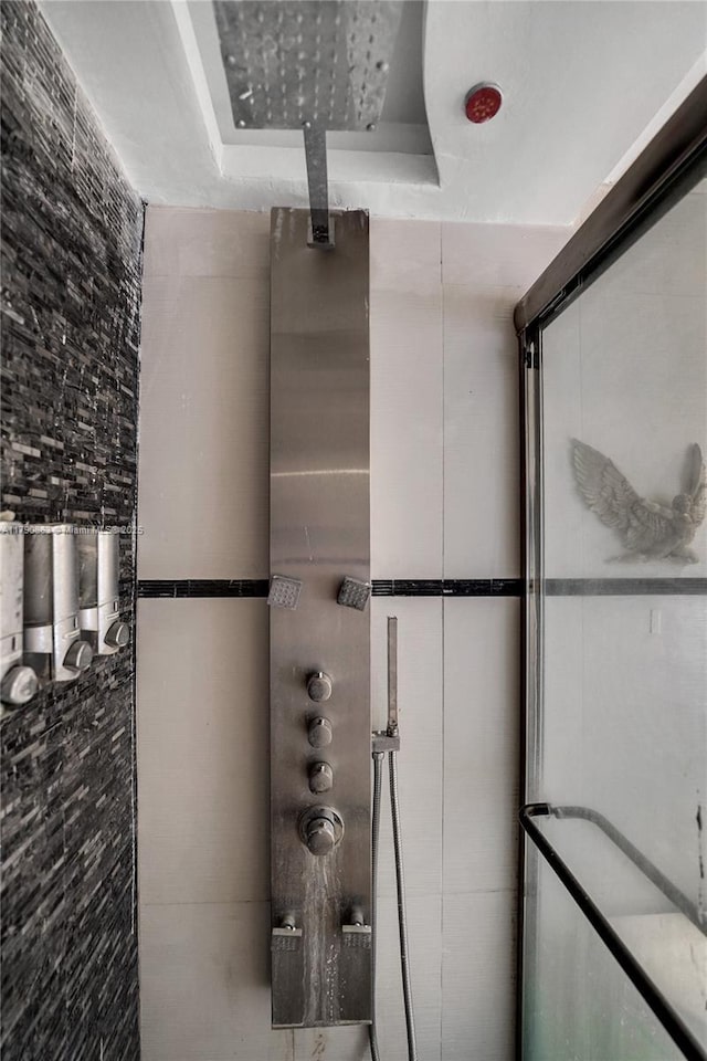 full bath featuring a tray ceiling and a tile shower