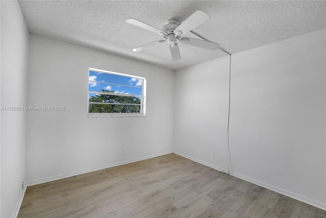empty room with baseboards, ceiling fan, a textured ceiling, and wood finished floors