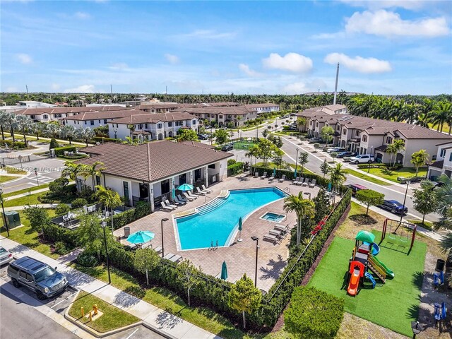 pool featuring a patio area, a residential view, and playground community