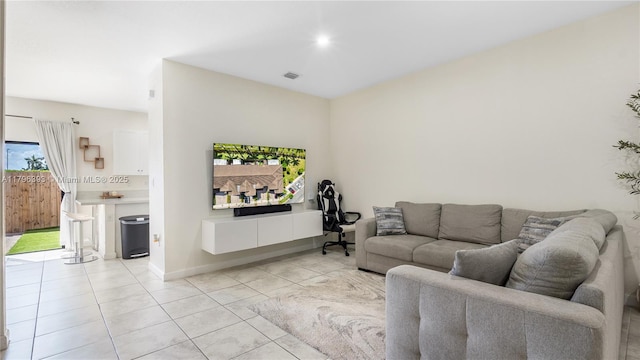 living area with baseboards, visible vents, and light tile patterned flooring