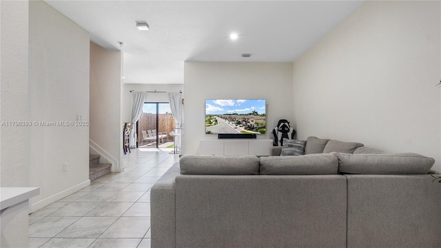 living room featuring light tile patterned floors, stairs, baseboards, and visible vents