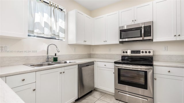 kitchen featuring light countertops, stainless steel appliances, white cabinets, and a sink