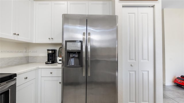 kitchen with white cabinetry, light tile patterned floors, and appliances with stainless steel finishes