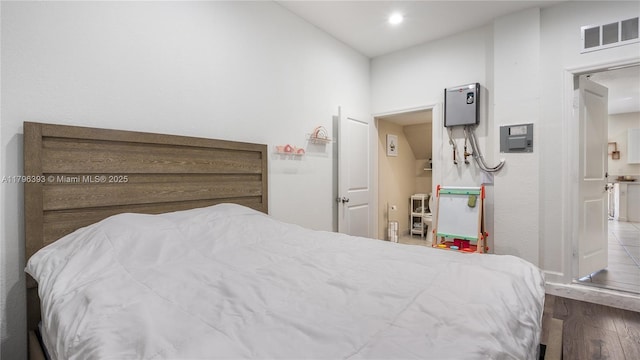 bedroom featuring visible vents and wood finished floors