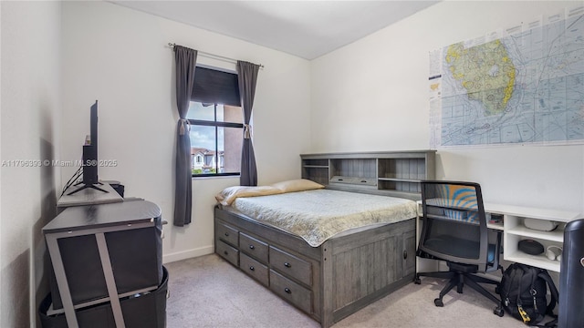 bedroom with baseboards and light colored carpet
