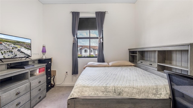 bedroom featuring light colored carpet and baseboards