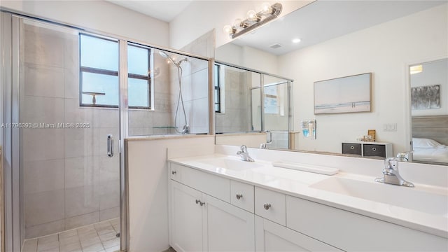 bathroom featuring double vanity, a stall shower, and a sink