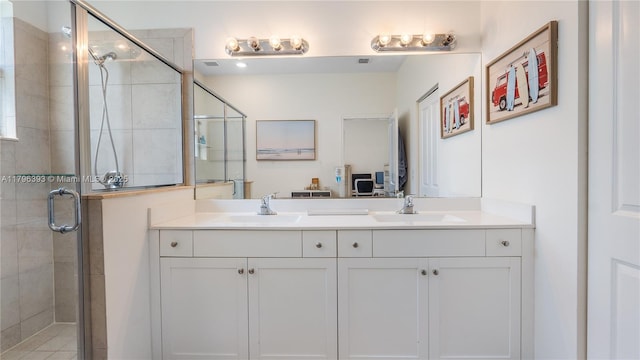 full bathroom with a sink, double vanity, and a shower stall