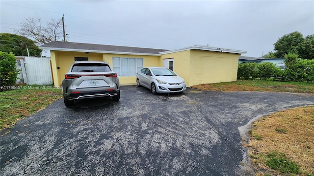 view of front of home with stucco siding and fence