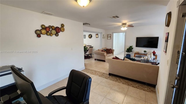 living area featuring visible vents, baseboards, light tile patterned flooring, and ceiling fan