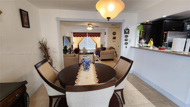 dining area featuring baseboards, light tile patterned flooring, and ceiling fan