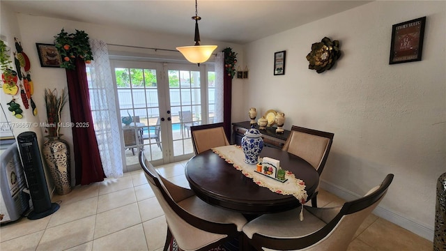 dining space featuring baseboards, french doors, and light tile patterned flooring