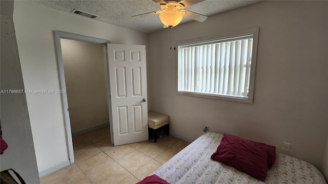 tiled bedroom featuring a textured ceiling, visible vents, and ceiling fan